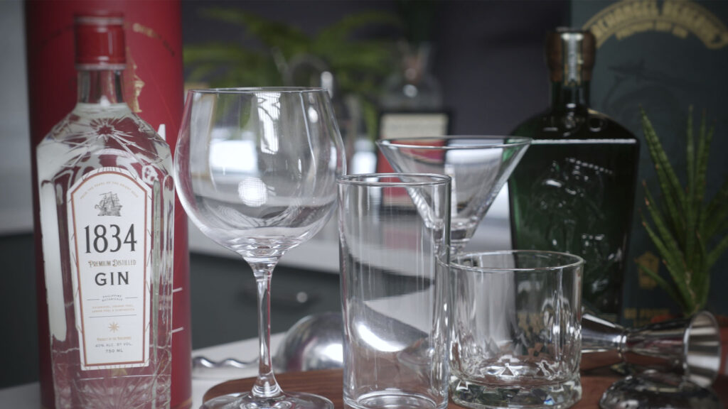 Sip in Style: The Gentleman’s Fieldguide to Choosing the Right Gin Glass Gin is more than just a spirit—it’s an experience. Every drink you prepare tells a story and every sip an important chapter. And here’s the plot twist: the glass you choose isn’t just a vessel; it’s a co-star in this botanical drama. Pick the wrong one, and you might as well be drinking from a shoe, though we don’t recommend testing that theory. So, let’s talk glassware—because life’s too short for mediocre gin moments. Whether you like your Gin neat, with Tonic water or shaken not stirred with complimentary spirits, the right glass doesn’t just hold your drink—it elevates it. The Rocks Glass Also known as the Old Fashioned glass, this sturdy little hero is for those who like their Gin uncomplicated. If your idea of bliss is a sipping you Gin neat or maybe on the rocks with a twist (or maybe a splash of bitters), this is your go-to. Why it works: -The medium is the message. And the message is simplicity: A simple glass for Gin by itself or Gin with a few accomplices and some ice. Best for: Gin neat or classic Gin cocktails like the Negroni, Gimlet, or a simple Gin-and-Bitters. The Copa Glass If you like longer Gin drinks like a classic G&T a classic highball is more than sufficient. But the large bowl and long stem of the Copa de Balon or Gin Balloon takes this classic cocktail up several notches. Why it works: - Big Bowl = Big Aromas – The wide bowl traps the gin’s botanicals and lets the tonic’s effervescence dance upward, hitting your nose like a fragrant fireworks display. - Plenty of Ice Real Estate – More space means slower dilution, keeping your drink crisp and cold. Plus handling your glass from the long stem keeps the warmth of your hand from warming your drink. - Drama Factor – Let’s be honest, a G&T in a Copa looks like it belongs on a yacht. Even if you’re drinking it in sweatpants. Best for: Gin-and-tonics (obviously), but also floral gins that benefit from a little aromatic breathing room. The Martini Glass The Martini glass is the James Bond of glassware—sleek, stylish, and just a little bit dangerous (urbane handling is a must if you want to keep spills to a minimum). Why it works: - Elegant Sips – The wide, shallow bowl ensures each sip hits your palate just right, balancing gin’s botanicals with vermouth’s herbal kiss. - The Stem Stays Cool – No warm hands messing with your drink’s temperature. - Instant Class – Holding one makes you feel like you should be wearing a tuxedo or a little black dress. Best for: Martinis, no prizes for guessing that one but also other gin cocktails like the Aviation or a Corpse Reviver No. 2. Final Thought: Glass Matters But… Gin is a spirit of nuance—each variety has its own personality, and the right crystal lets it shine so select your Gin just as wisely. Whether you enjoy it Neat, with ice or as the star of endless Gin cocktails. Choose well, gents and Cheers to better sipping!